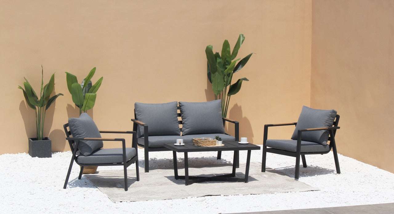 Meble ogrodowe aluminiowe zestaw sofa i fotele z szarymi poduszkami i stolikiem na tarasie