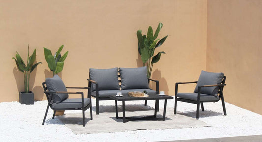 Meble ogrodowe aluminiowe zestaw sofa i fotele z szarymi poduszkami i stolikiem na tarasie