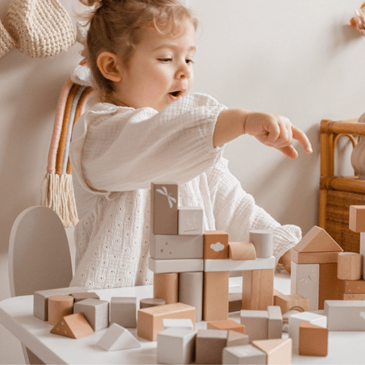 Child playing with Label Label wooden blocks set in natural and nougat colors on table