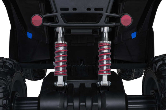 Close-up view of red coil rear shock absorbers and rugged wheels on Quad Fast Wheel kids' yellow ride-on toy