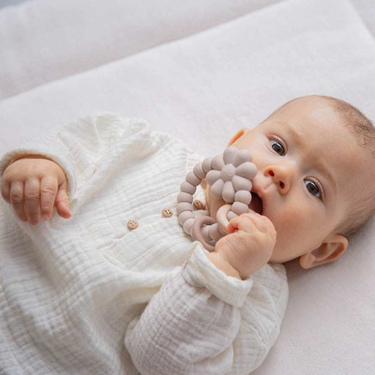 Baby holding Label Label Gryzak silicone flower teether for soothing gums during teething
